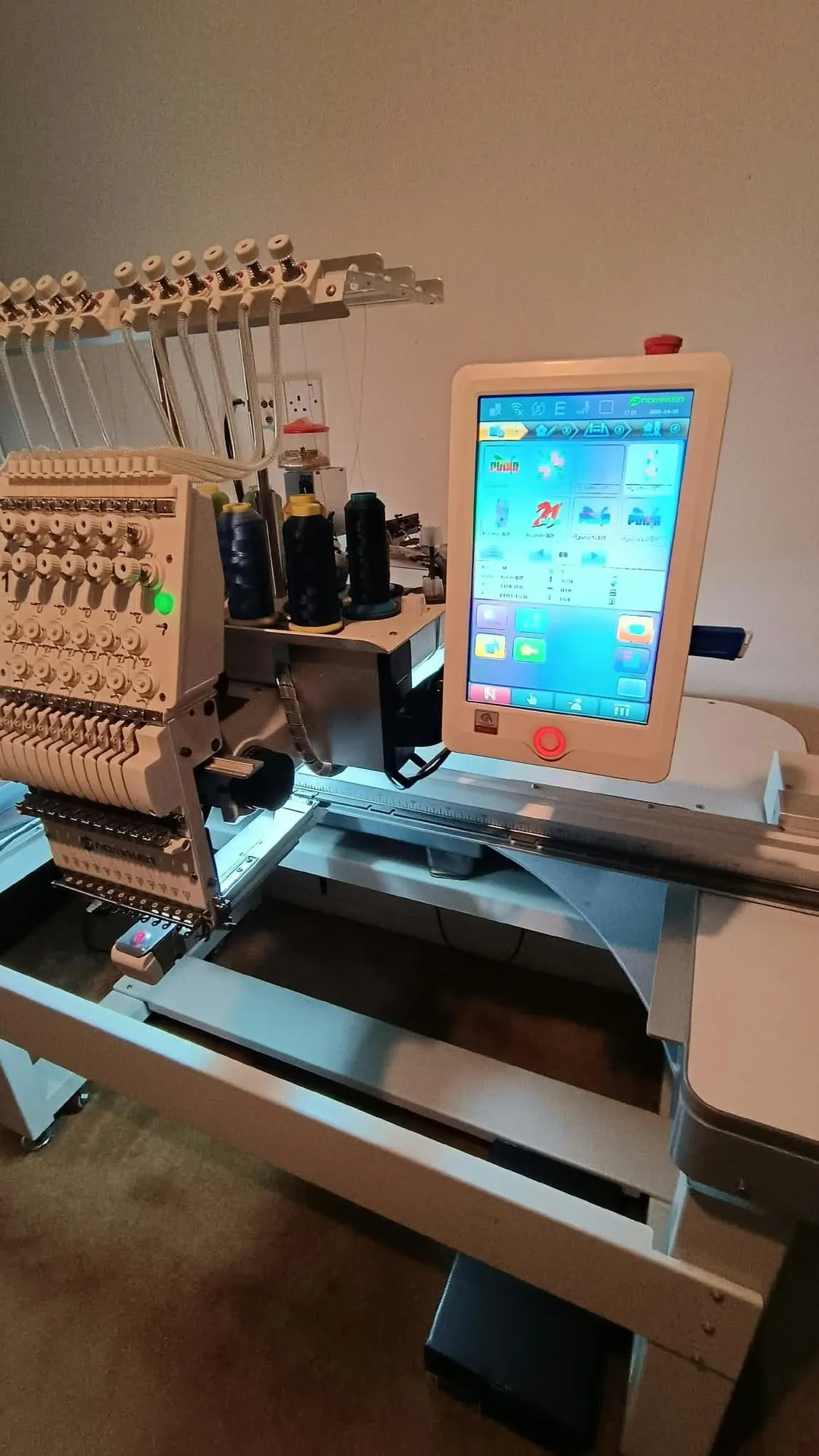 The heads of a multi-needle embroidery machine with coloured threads