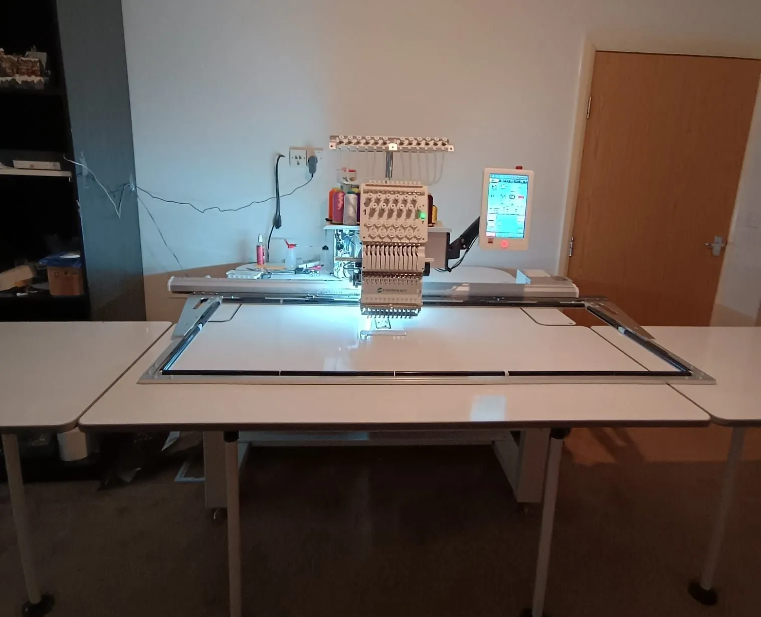 A multi-needle embroidery machine on its table in the RIUS Design studio